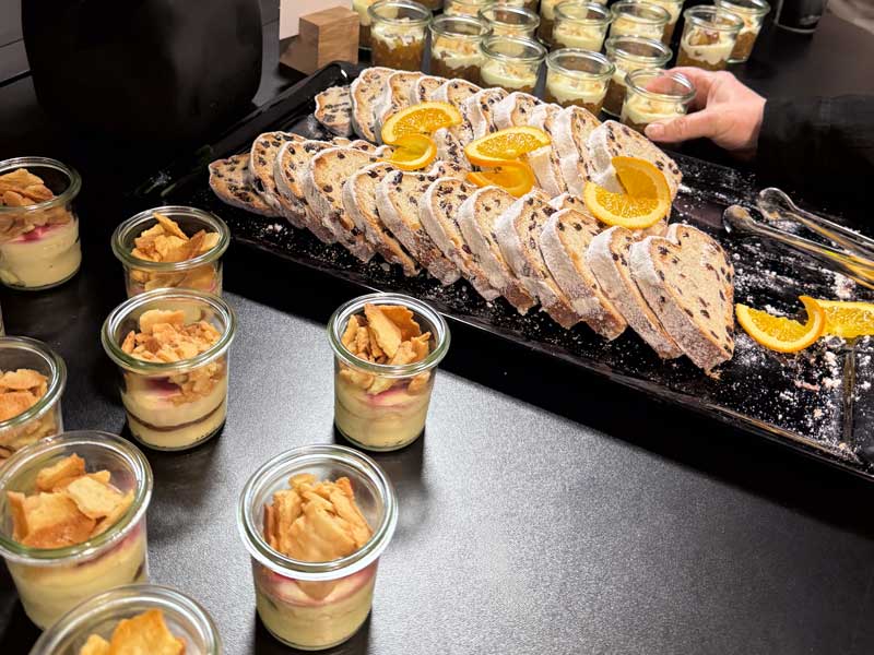 Catering-Desserts mit geschnittenem Kuchen und Dessertgläsern auf Eventbuffet